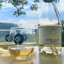 Load image into Gallery viewer, Three wine glasses half-filled with the 2016 Garnet Valley Ranch Winery Sparkling Brut. The effervescent bubbles shimmer in the light, as the golden-hued sparkling wine delights the senses. A perfect blend of elegance and indulgence, inviting a toast to memorable moments | Farm to Glass Wine Tours