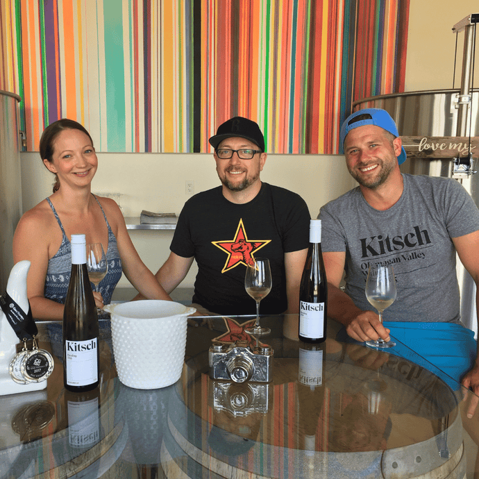 Two guests, and winemaker Grant Biggs of Kitsch wines in Kelowna sit down and pose for a picture during their private tasting.  | Farm to Glass Wine Tours