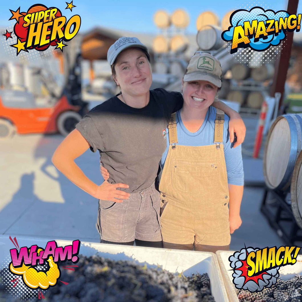 Picture of Alyssa Hubert of L-St Projects and Creek & Gully Cider poses with her arm around winemaker Jordan Kubek of Lightning Rock Winery and Pamplemousse Jus in front of two large bins of Pinot Noir grapes at harvest time in Summerland, BC